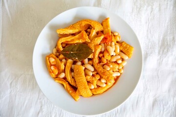 A classic Brazilian dish known as dobradinha, prepared with beef tripe, white beans, and tropical spices, served with traditional farofa made from toasted cassava flour.