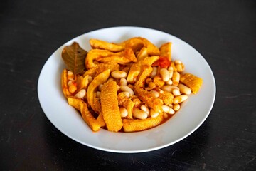A classic Brazilian dish known as dobradinha, prepared with beef tripe, white beans, and tropical spices, served with traditional farofa made from toasted cassava flour.