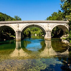 Fototapeta premium Ancient stone bridge over a calm river