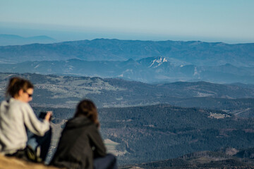 tourists admiring mountain peaks in autumn
