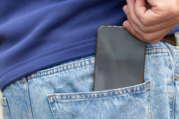 A smartphone in the back pocket of a man's jeans