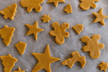 Making gingerbread christmas cookies. Raw gingerbread cookies in tree, star and gingerbread man...