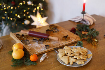 Making gingerbread christmas cookies. Gingerbread cookies on plate, dough, rolling pin and metal...