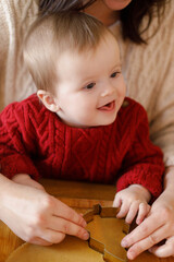 Happy mother with cute baby son making gingerbread christmas cookies together with metal cutters,...