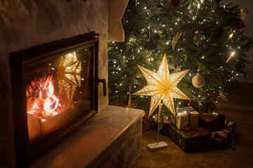 Merry Christmas! Stylish wrapped christmas presents, illuminated star under festive decorated...