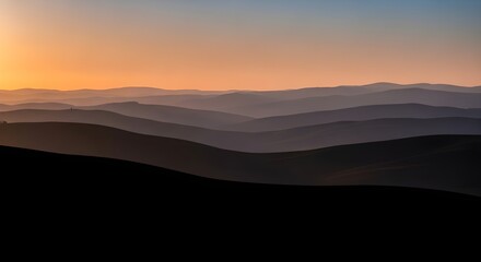 Stunning layered mountain landscape at sunset with warm golden sky and tranquil atmosphere