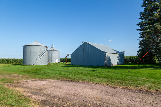 Pole barn shed and grain bins made of corrugated steel on a rural Midwest farm field
