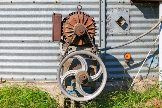 Grain bin unloading auger electric motor and mechanical drive wheel assembly