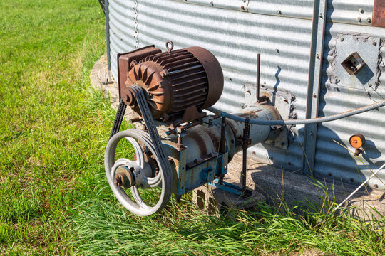 Grain bin motor and auger pulley system on farm silo close up