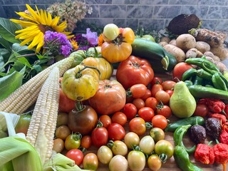 Flat lay of heirloom vegetables including hot peppers, tomatoes, and colored corn