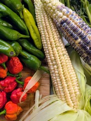 Flat lay of bountiful harvest with Carolina Reapers, heirloom tomatoes, and flowers