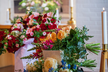 Floral tributes and candles during funeral ceremony.