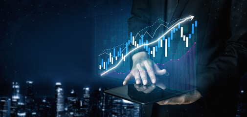 A businessman is analyzing financial data on a tablet, with growing graphs projected against a city...