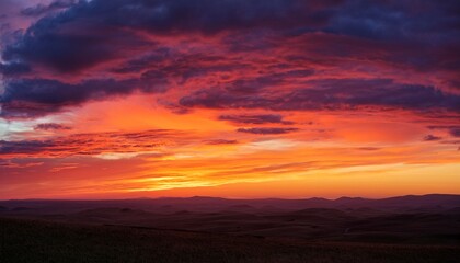 Fototapeta premium dramatic sunset over a vast landscape with colorful clouds and distant horizon captured during twilight hours