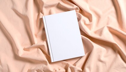 Fototapeta premium Blank Paperback Book Mockup on Peach Cloth in Overhead Daylight Editorial Style