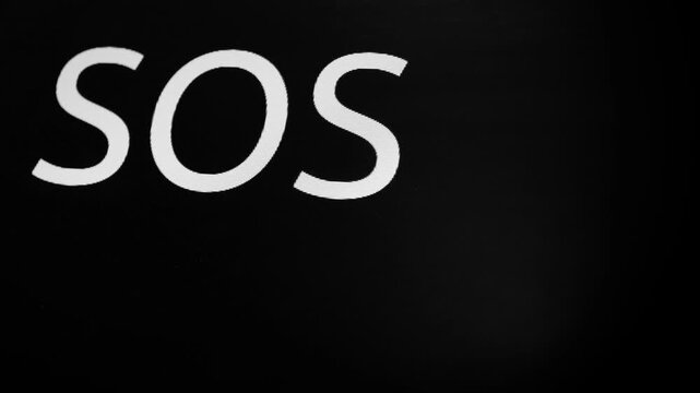 Morse code transmits SOS as three dots, three dashes, three dots. SOS symbol on black monitor display. Black screen with flashing stripe and three letters SOS. International distress signal