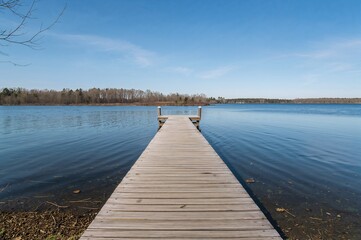 Fototapeta premium Tranquil Wooden Dock Extending into a Calm Lake