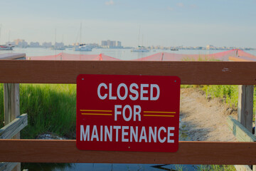 Maintenance Closure Sign Overlooking Coastal Scenery and Boats Gulfport, FL. Wooden fencing, with a...