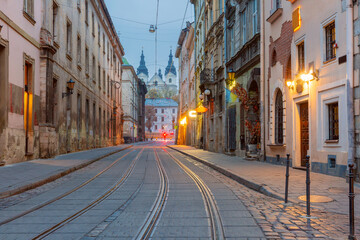 Narrow cobblestone street with tram tracks and historic buildings in Lviv, Ukraine