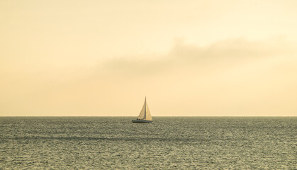 Fototapeta premium Sailboat on Lake Geneva at sunset with sun rays through clouds