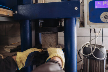 Technician placing concrete cube into compressive strength testing machine