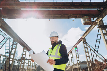 Engineer reading blueprint at concrete production plant