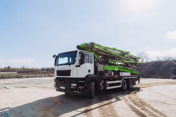 Concrete pump truck parked at construction site on sunny day