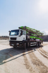 Concrete pump truck parked at construction site on sunny day