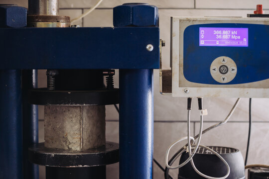 Compression testing machine pressing concrete cylinder for strength test