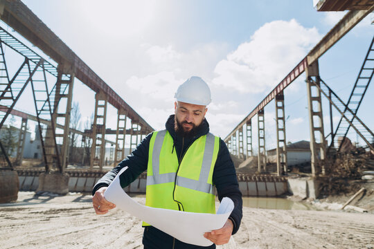 Engineer reading blueprint at concrete production plant