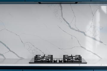 Gas cooktop. Marble backsplash. Minimal kitchen