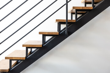 Obraz premium Side view of modern staircase. Loft interior. Wood and black steel.