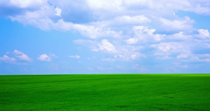 Timelapse of moving clouds over a green field. High quality 4k footage