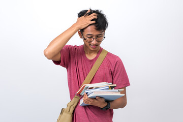 Tired young student carrying lots of books too much homework isolated on white background.