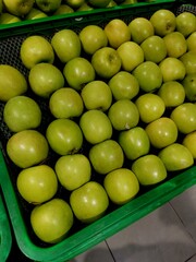 Green apples neatly arranged in rows