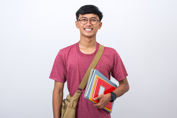 Portrait of a smiling college student with books and sling bag isolated on white background.