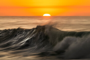 Powerful wave at sunrise in Bronte Beach, Sydney, Australia, captured with slow shutter speed to...