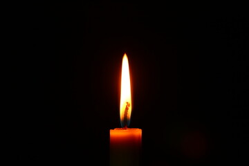 Closeup burning candle on dark black background, candle fire flame light with empty space. Ritual with romantic candle wax fire	
