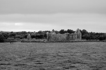 A large stone building sits in a field of grass