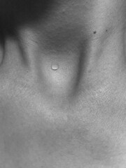 Naklejka premium A drop of water on the body. Black and white photo of the neck. Body aesthetics. 