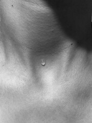 Fototapeta premium A drop of water on the body. Black and white photo of the neck. Body aesthetics. 