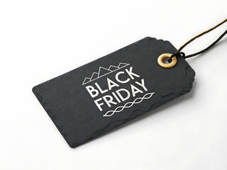 A black friday tag made of slate with a gold ring and string on a white surface for sale promotion