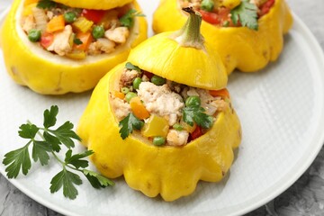 Tasty stuffed pattypan squashes on grey textured table, closeup