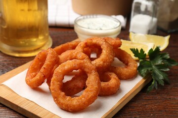Fried squid rings served on wooden table, closeup