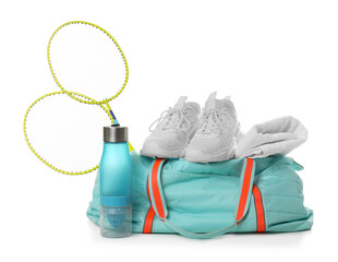 Stylish sports bag with badminton rackets, towel, bottle and sneakers isolated on white
