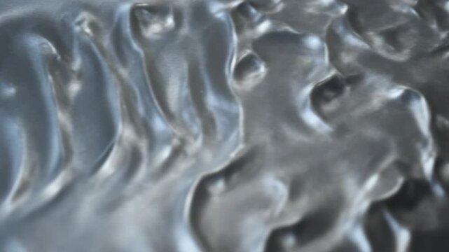 Abstract metallic surface close-up with flowing textures and reflective highlights