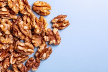 Obraz premium Shelled walnuts scattered on a light lavender surface