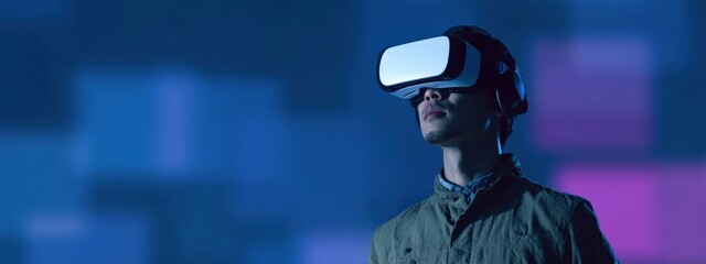 Young man wearing VR headset exploring virtual reality world with colorful lights in the background