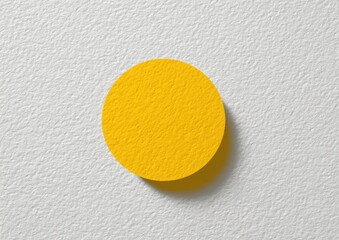 A bright yellow circle on a textured white surface