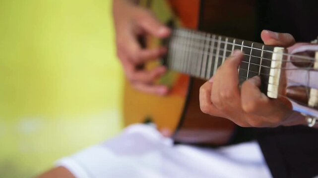 Lifestyle concept. Young asian musician playing guitar in living room at home on this weekend. Relaxing with song and music. Asian man having fun playing acoustic guitar